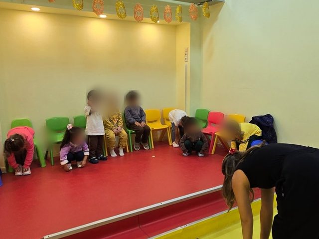 Jimnastik salonunda minderler üzerinde hareket eden çocuklar